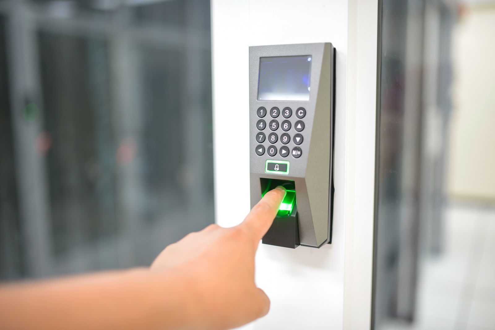 A person using a fingerprint scanner at a secure entry point in an office.